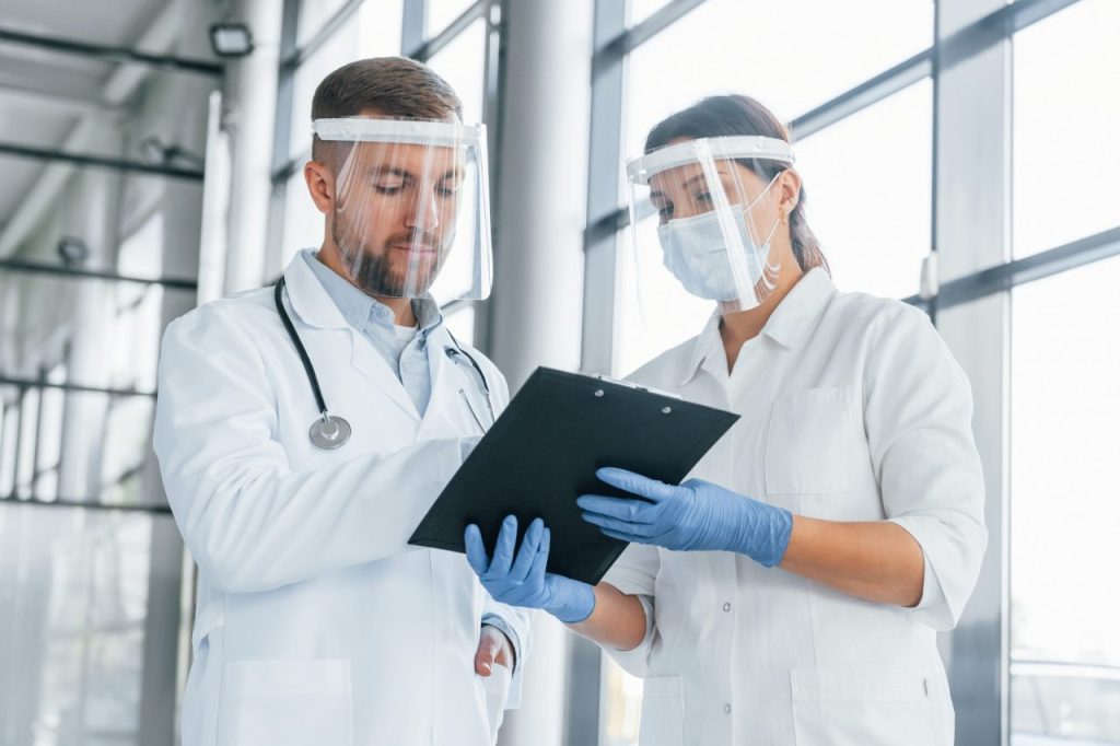 working with documents two doctors in white coats is in the clinic